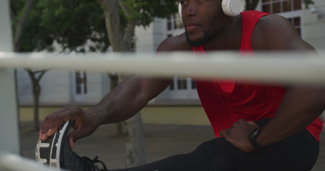 Focused Man Stretching Outdoors with Headphones Wearing Sportswear - Free Images, Stock Photos and Pictures on Pikwizard.com