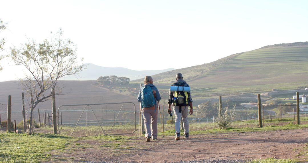 Two Hikers Walking in Rural Countryside - Free Images, Stock Photos and Pictures on Pikwizard.com