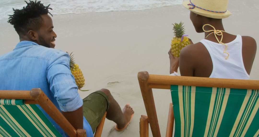 Couple Relaxing with Pineapple Drinks on Tropical Beach