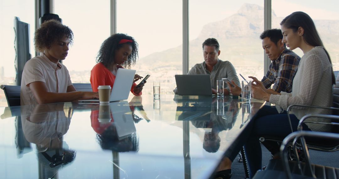 Diverse Business Team Using Mobile Devices in Boardroom