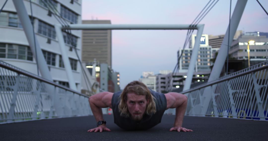 Athletic Man Doing Push-Ups on Urban Bridge at Dusk - Free Images, Stock Photos and Pictures on Pikwizard.com