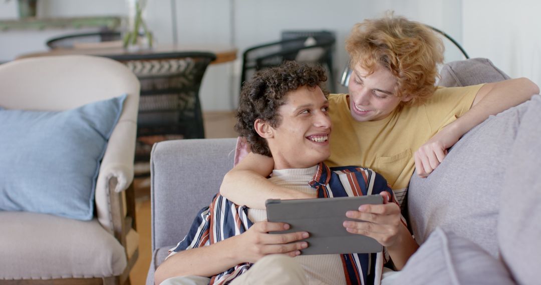 Joyful Diverse Couple Relaxing Together with Tablet at Home