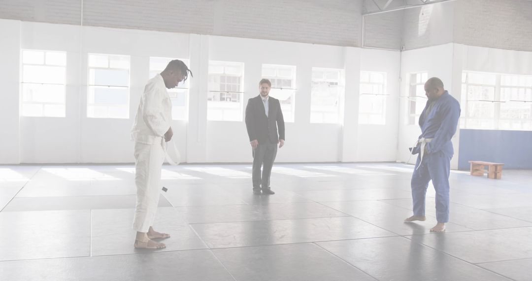 Bowing Martial Artists Preparing for Match on Tatami Mats in Bright Minimal Dojo