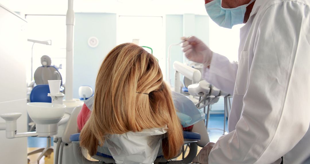 Dentist Performing Procedure on Patient in Dental Office - Free Images, Stock Photos and Pictures on Pikwizard.com