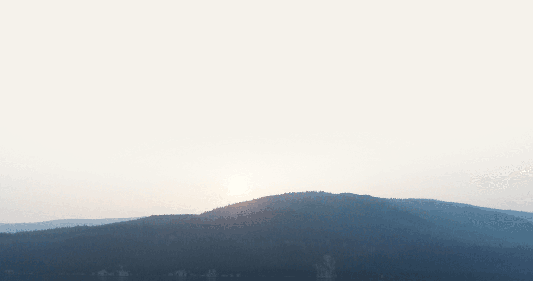 Transparent Sunrise Over Mountain Landscape with Clear Sky