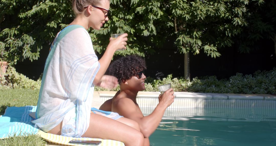 Diverse Couple Relaxing by Pool with Refreshing Drinks