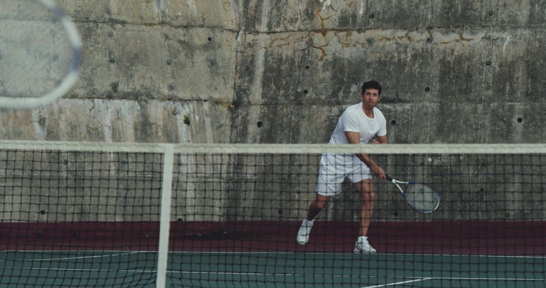 Man Playing Tennis Against Concrete Wall - Free Images, Stock Photos and Pictures on Pikwizard.com