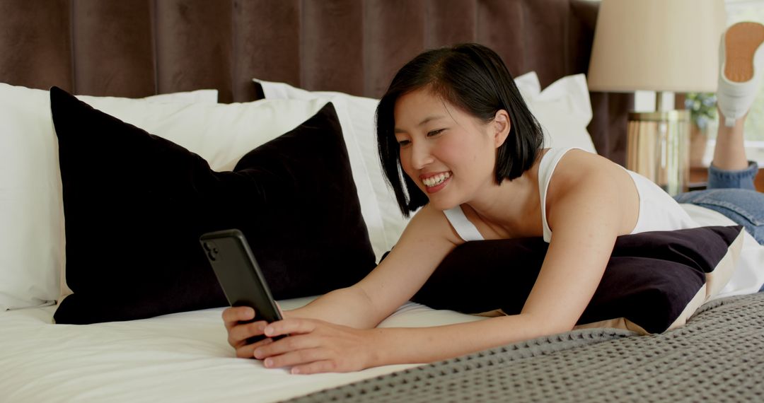 Woman Relaxing on Bed Enjoying Video Call on Smartphone