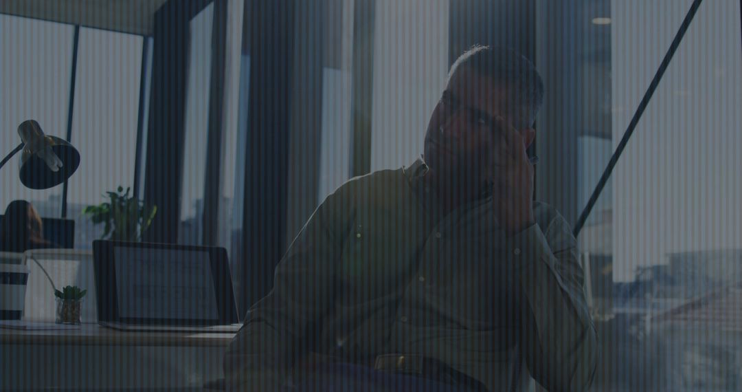 Mature Professional on Phone in Urban Open-Plan Office Environment