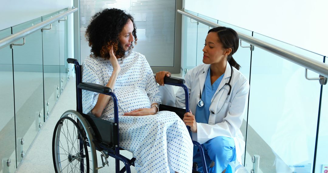 Doctor Assisting Pregnant Woman in Wheelchair at Hospital - Free Images, Stock Photos and Pictures on Pikwizard.com