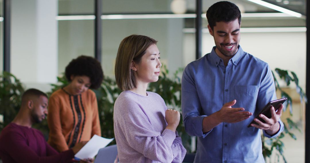 Diverse Professionals Collaborating with Digital Tablet in Modern Office