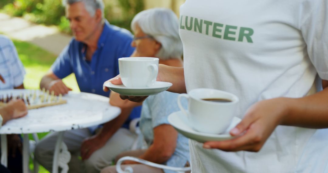 Volunteer Serving Coffee to Senior Citizens Outdoors - Free Images, Stock Photos and Pictures on Pikwizard.com