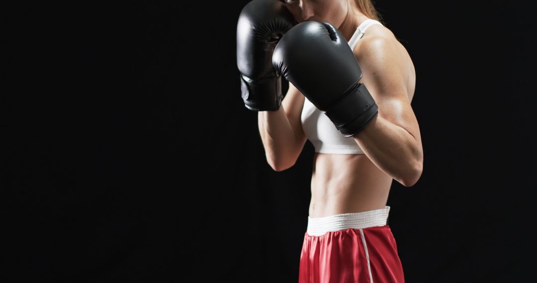 Determined Female Boxer Practicing Punches in Athletic Gear