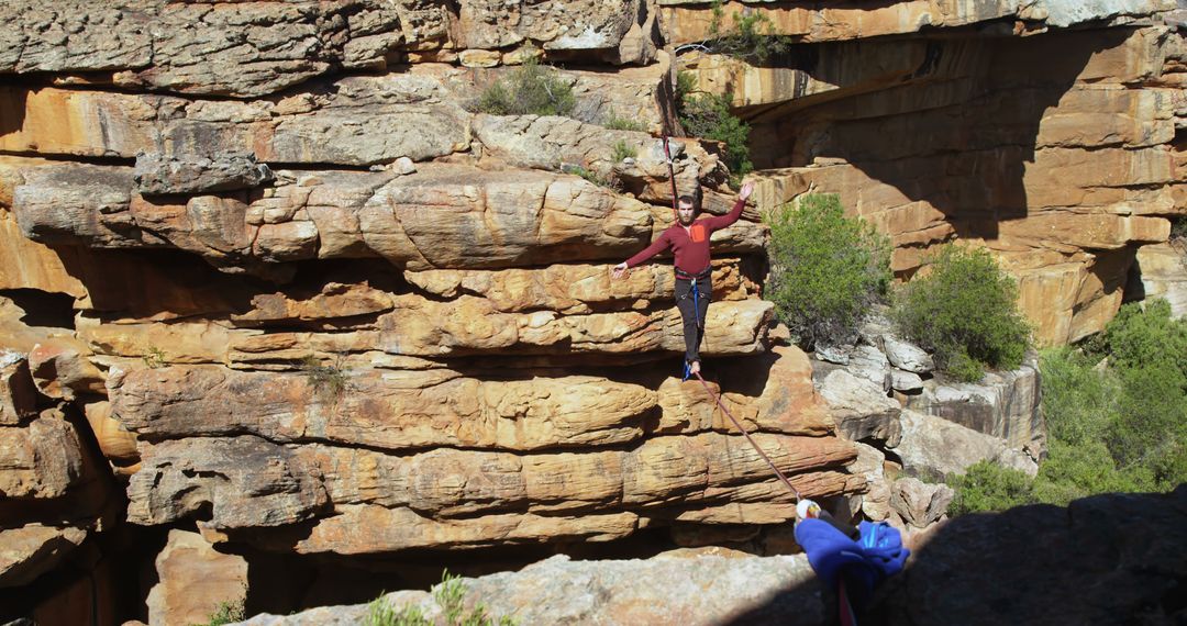 Man balancing on a slackline across rocky canyon - Free Images, Stock Photos and Pictures on Pikwizard.com