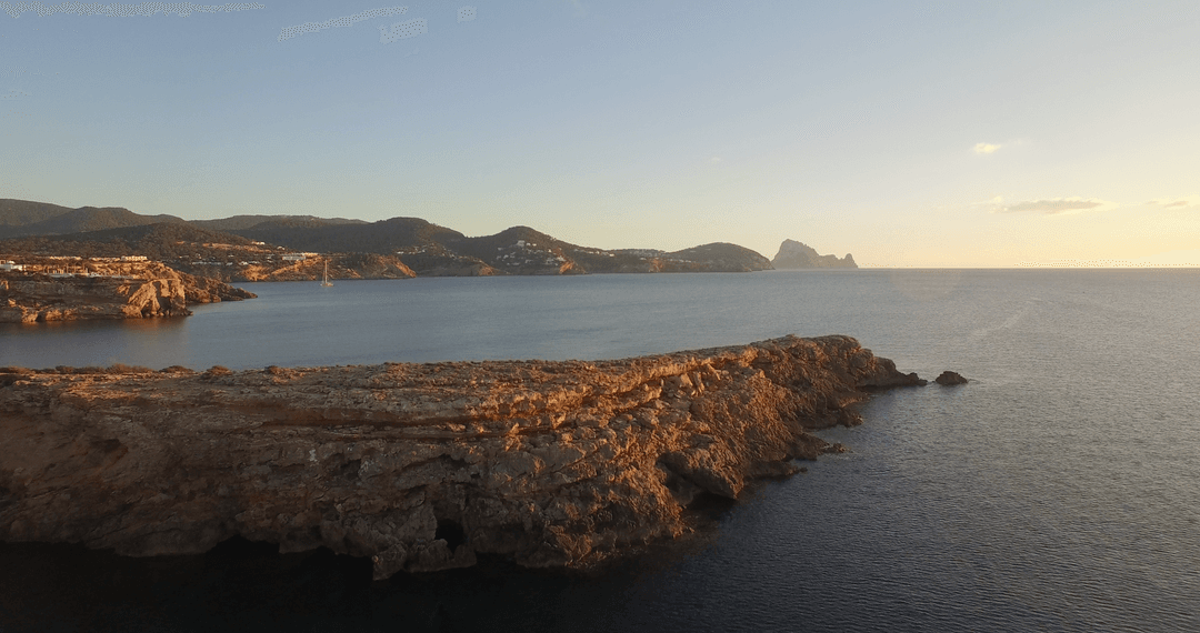 Breathtaking Rocky Coast at Sunset with Tranquil Sea Surface