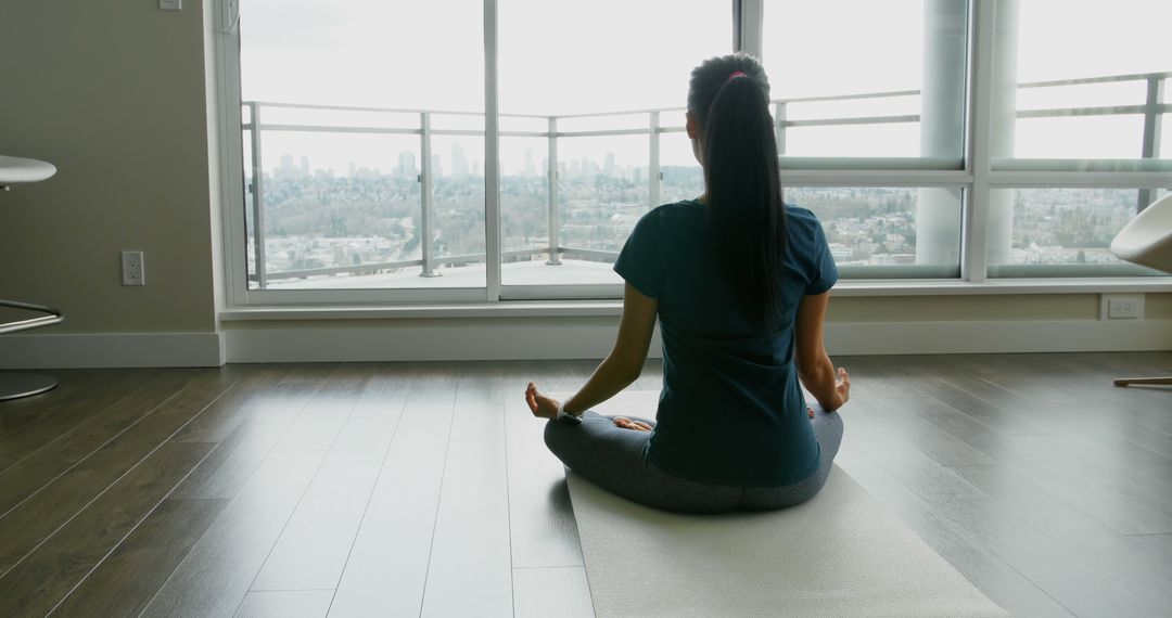 Woman Practicing Yoga at Home with Cityscape View - Free Images, Stock Photos and Pictures on Pikwizard.com