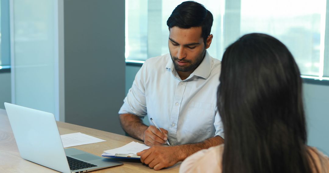 Middle Eastern Businessman Working on Laptop at Desk in Office