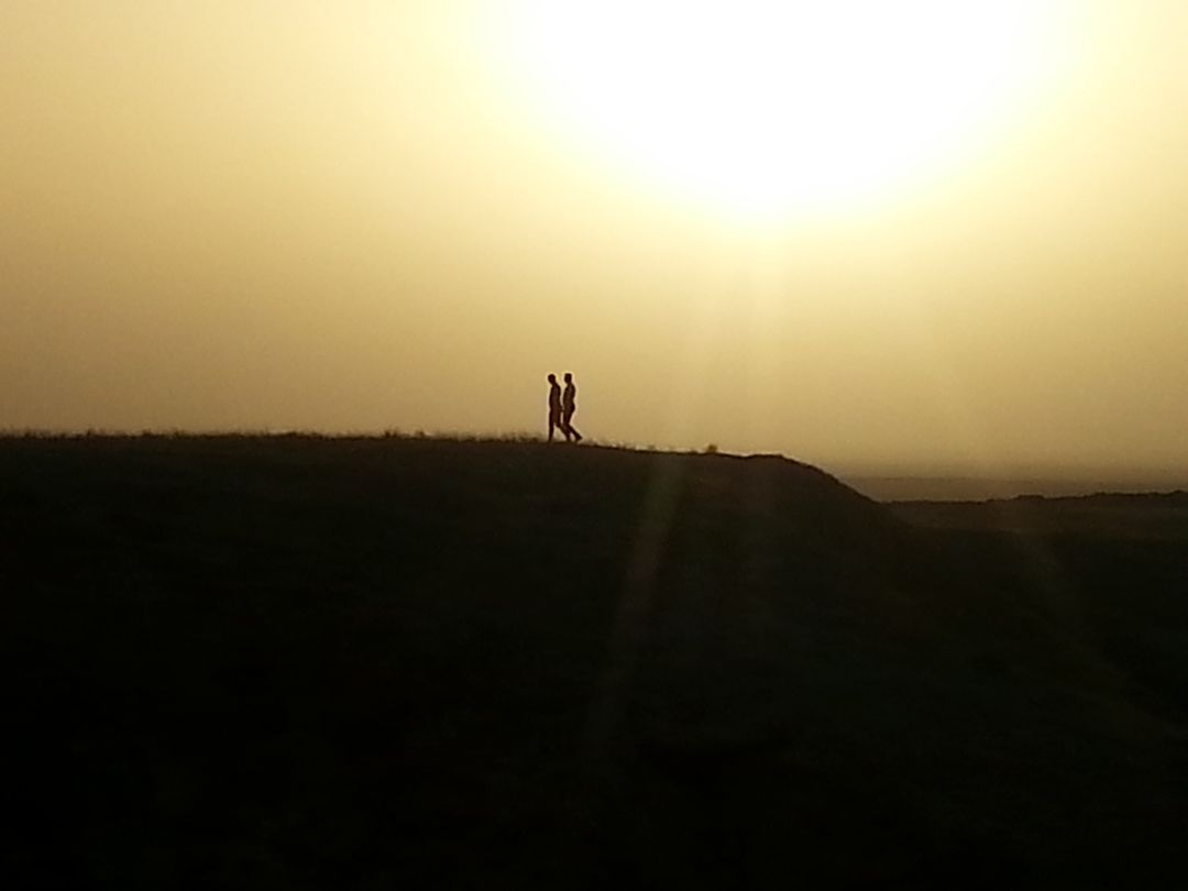 Silhouette of man standing on landscape against sky during sunset - Free Images, Stock Photos and Pictures on Pikwizard.com