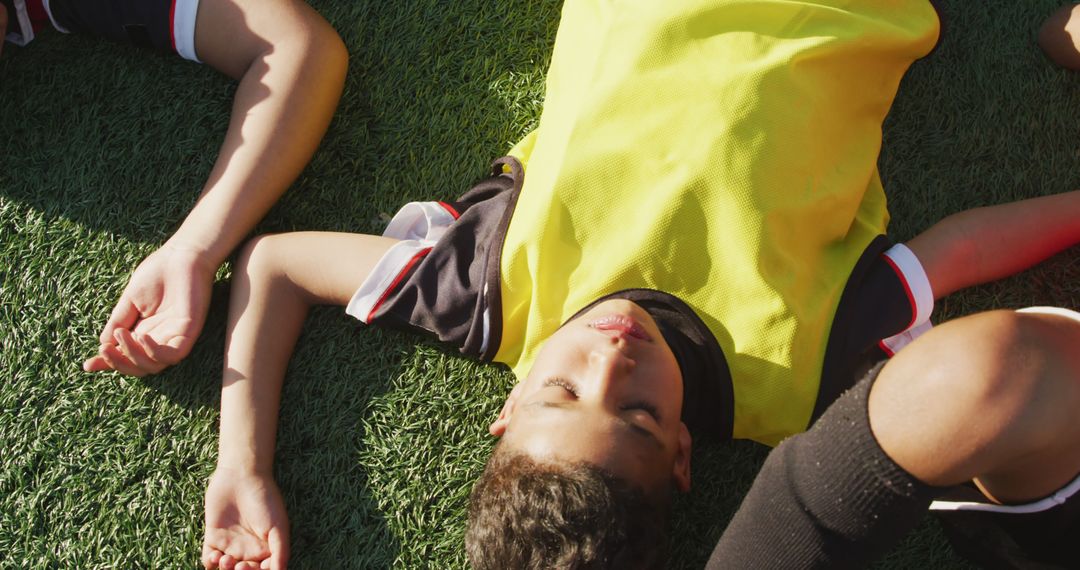 Exhausted Kid Lying on Soccer Field in Sunshine - Free Images, Stock Photos and Pictures on Pikwizard.com