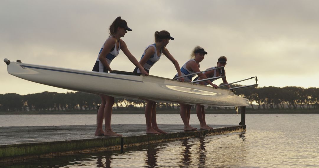 Women Rowers Preparing Boat for Rowing at Dusk Near Lake - Free Images, Stock Photos and Pictures on Pikwizard.com