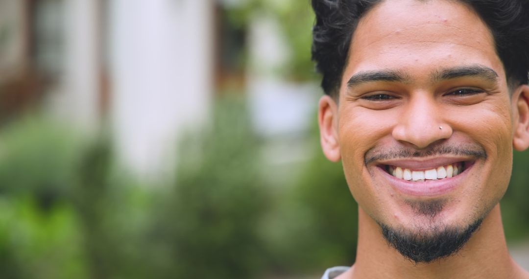 Smiling Man with Nose Stud Outdoors Shows Joyful Expression