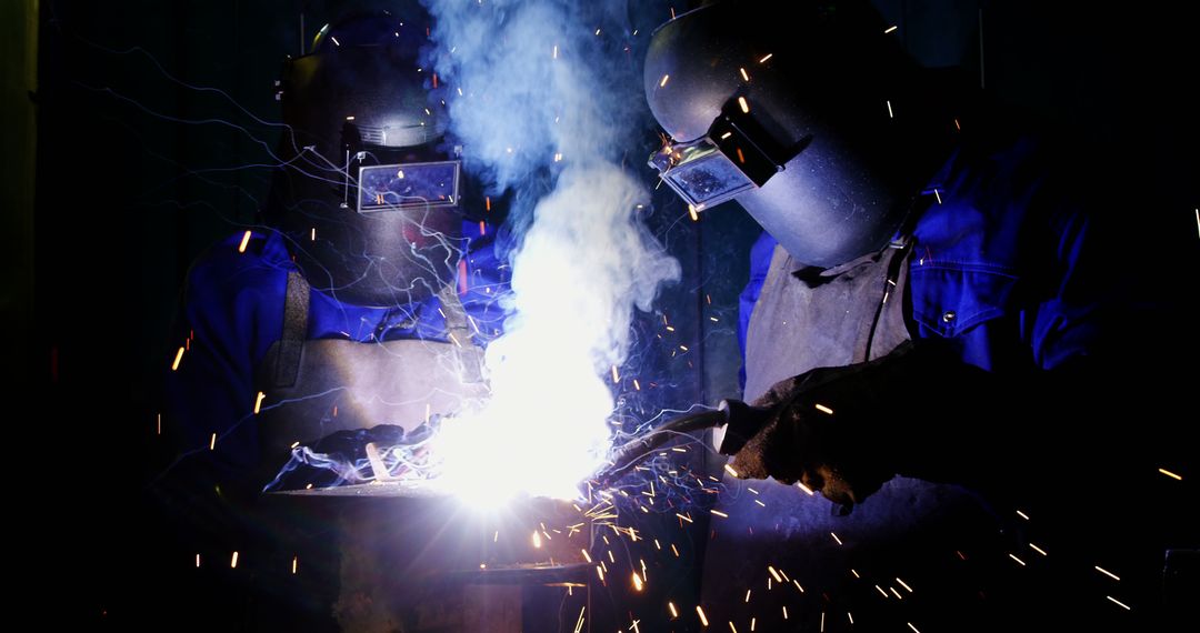 Industrial Workers in Protective Gear Welding with Sparks - Free Images, Stock Photos and Pictures on Pikwizard.com