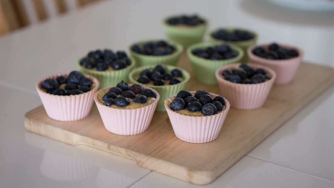 Homemade Blueberry Muffins in Silicone Baking Cups on Wooden Board - Free Images, Stock Photos and Pictures on Pikwizard.com