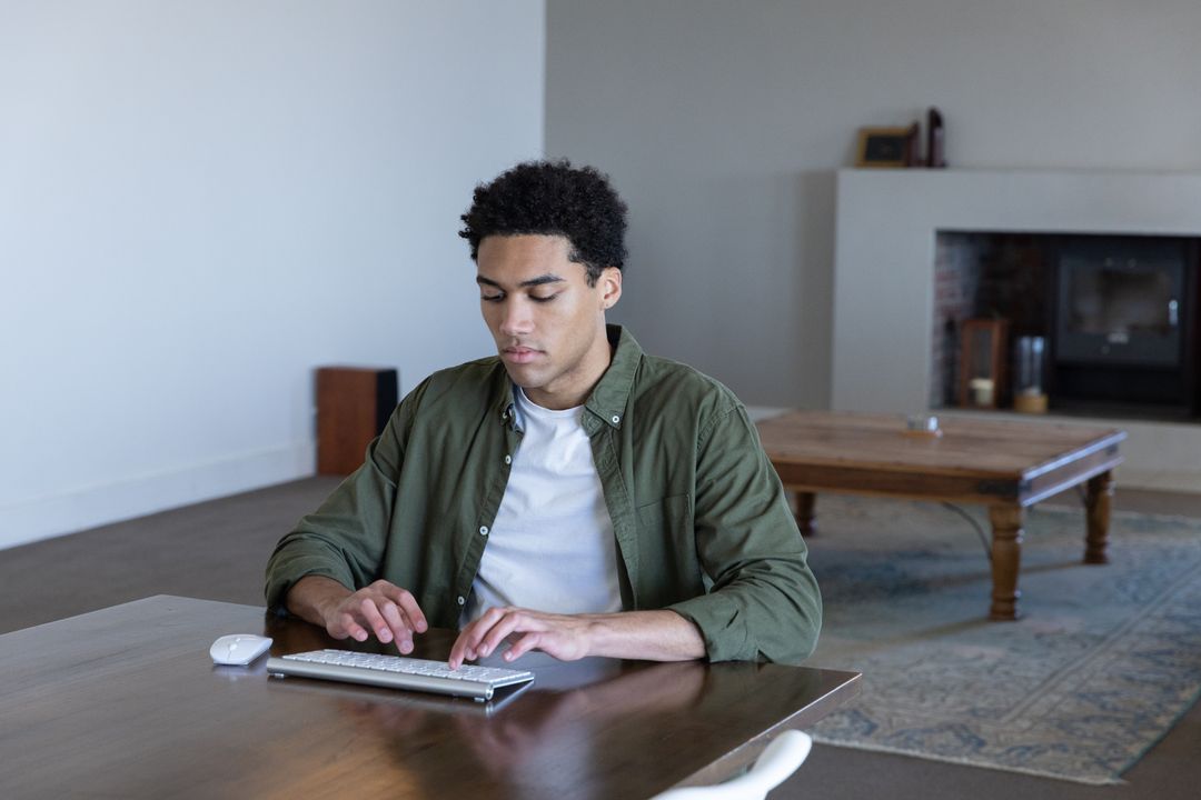 Focused Man Typing on Wireless Keyboard in Stylish Home Office
