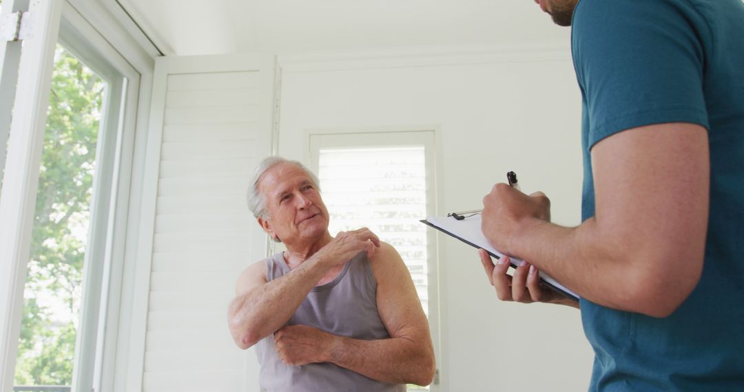 Senior Man Consulting Doctor About Shoulder Pain at Home - Free Images, Stock Photos and Pictures on Pikwizard.com