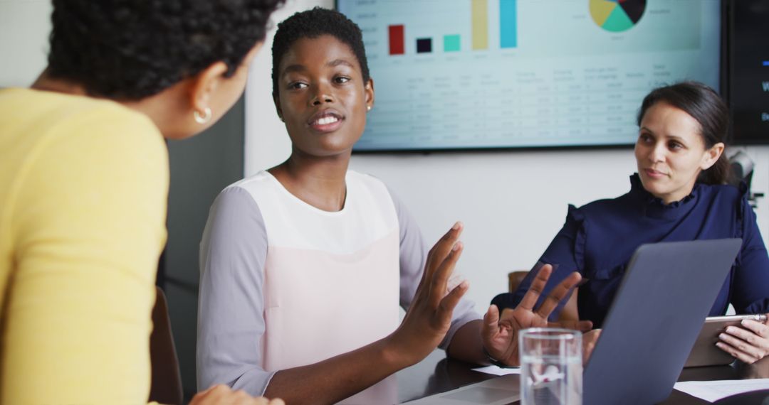 Diverse Businesswomen Collaborating with Laptops and Charts in Modern Office