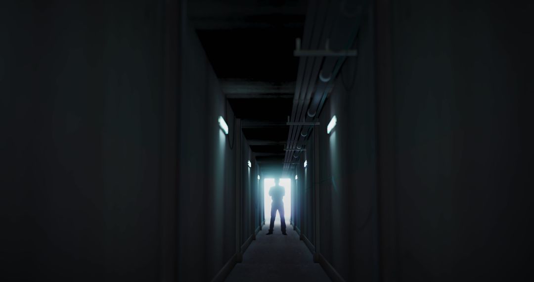 Silhouette Man Standing in Dark Corridor Illuminated by Light