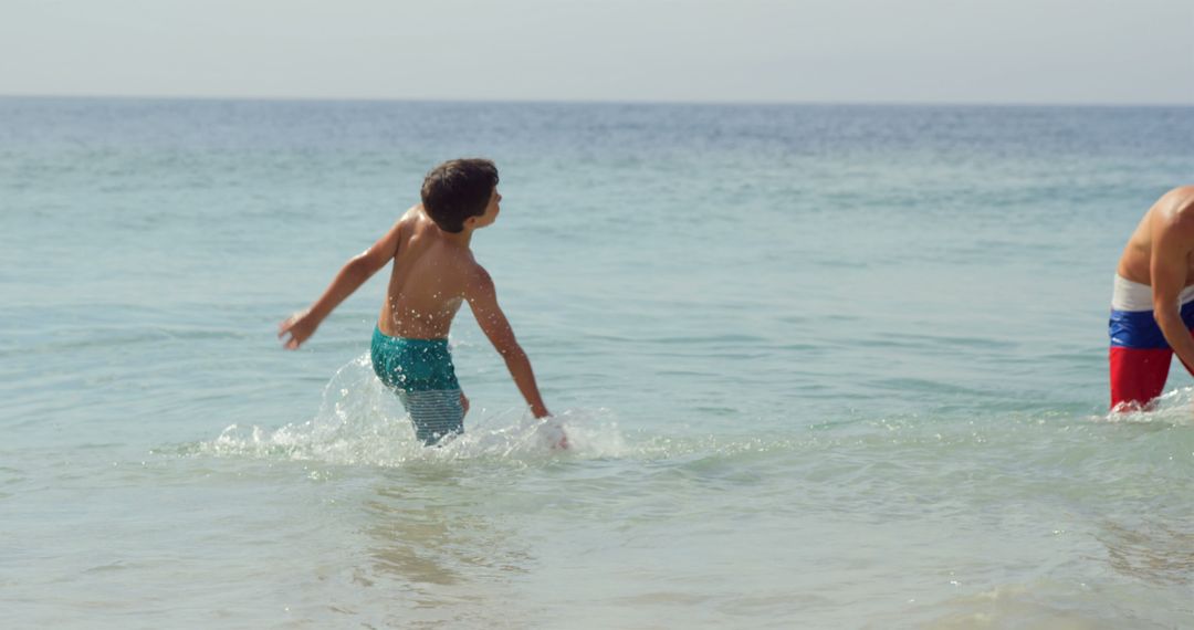 Young children playing in ocean waves on sunny beach day - Free Images, Stock Photos and Pictures on Pikwizard.com