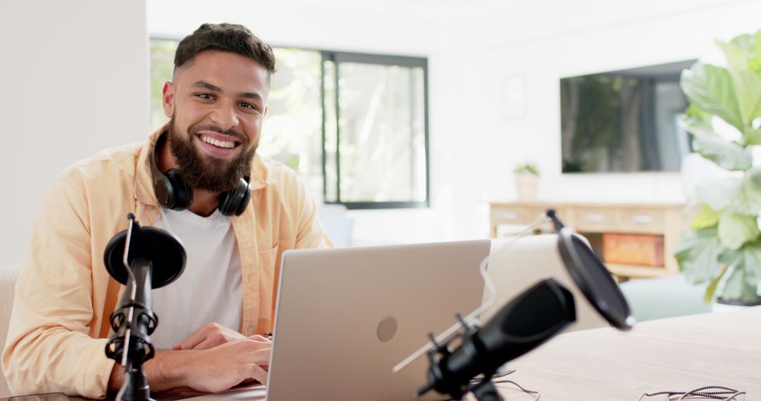 Smiling Male Podcaster in Bright Home Workspace