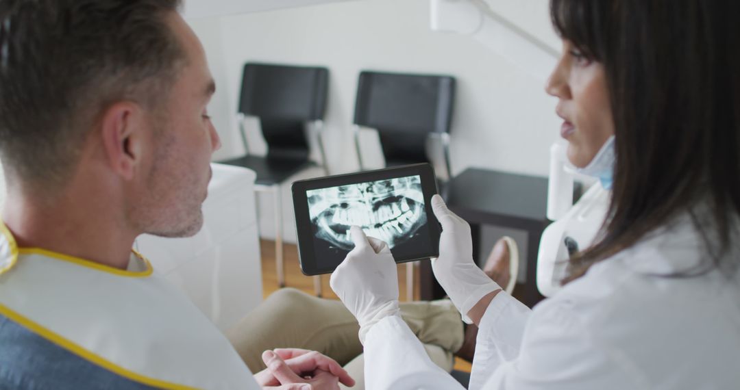 Dentist Showing X-ray Results on Tablet to Patient - Free Images, Stock Photos and Pictures on Pikwizard.com