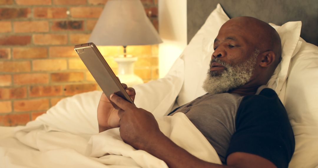 Senior Man Relaxing in Bed with Digital Tablet - Free Images, Stock Photos and Pictures on Pikwizard.com