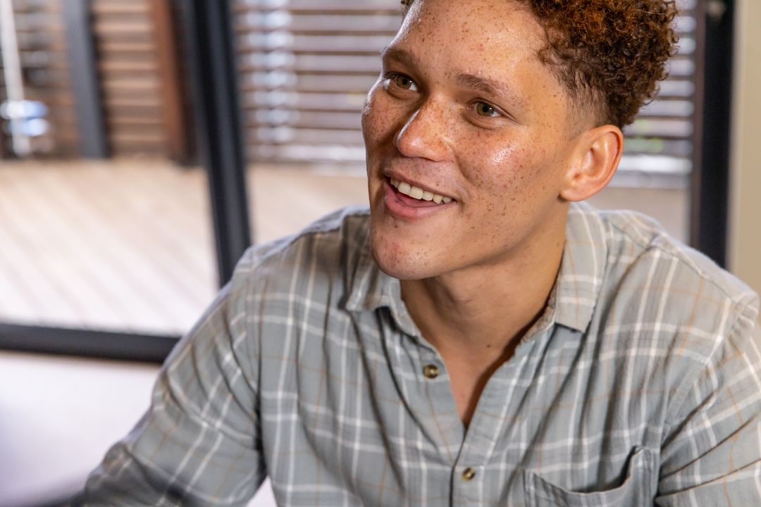Smiling Man in Casual Shirt Enjoying a Relaxed Home Environment