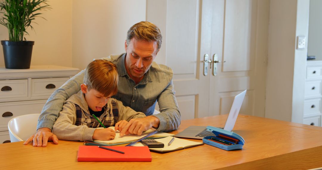 Caucasian Father Helping Son with Homework at Table in Comfortable Home Using Laptop 4k - Free Images, Stock Photos and Pictures on Pikwizard.com