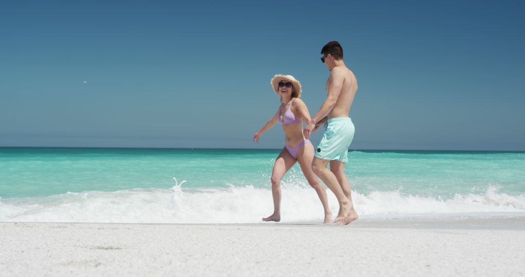 Happy couple enjoying a walk on a tropical beach - Free Images, Stock Photos and Pictures on Pikwizard.com