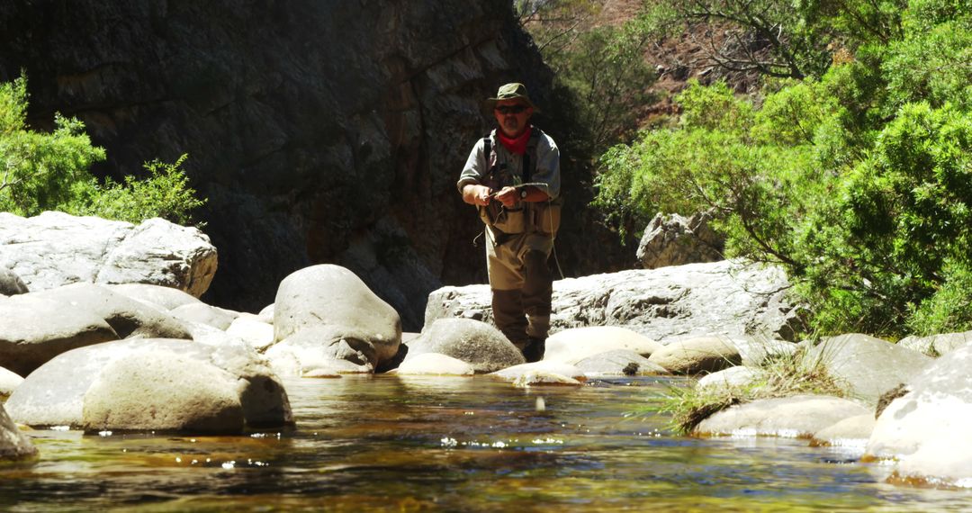 Man Fly Fishing in Mountain Stream on Sunny Day - Free Images, Stock Photos and Pictures on Pikwizard.com