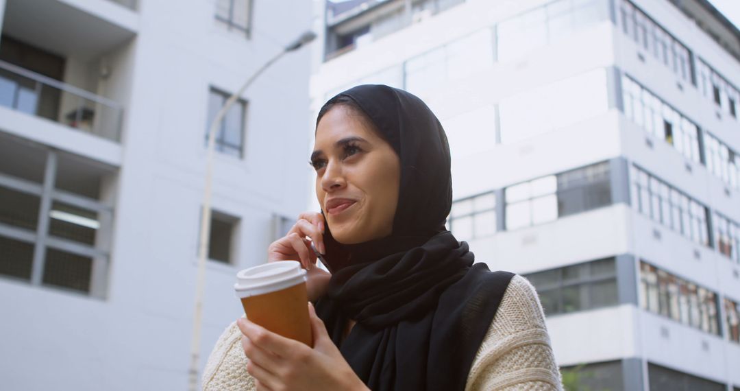 Confident Muslim Woman Talking on Phone with Coffee in Hand - Free Images, Stock Photos and Pictures on Pikwizard.com