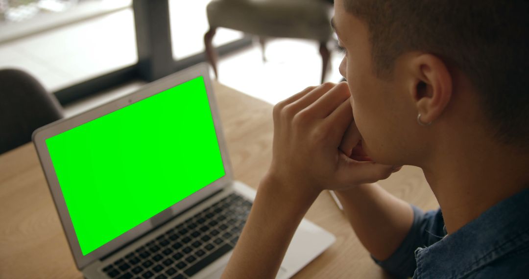 Man Contemplating At Desk With Green Screen Laptop - Free Images, Stock Photos and Pictures on Pikwizard.com