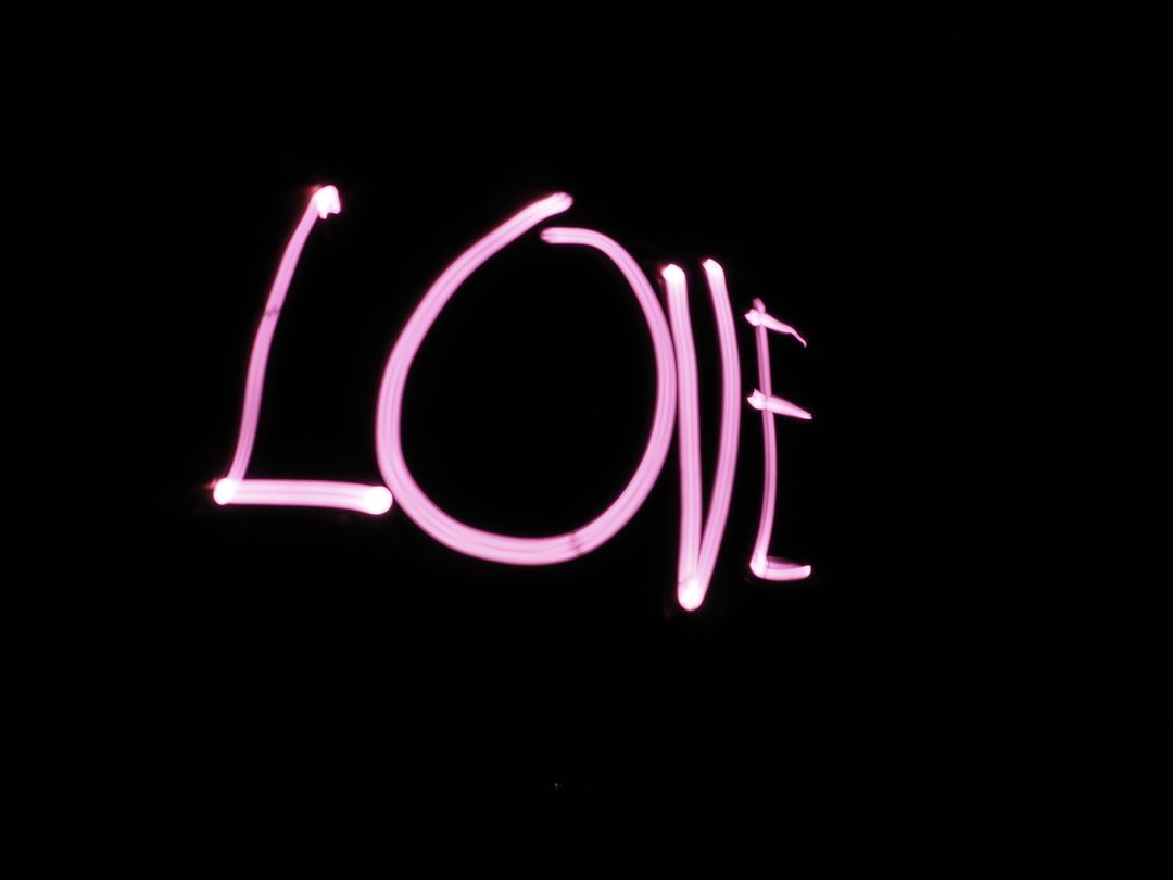 Neon Love Sign Glowing in Pink Light on Black Background - Free Images, Stock Photos and Pictures on Pikwizard.com