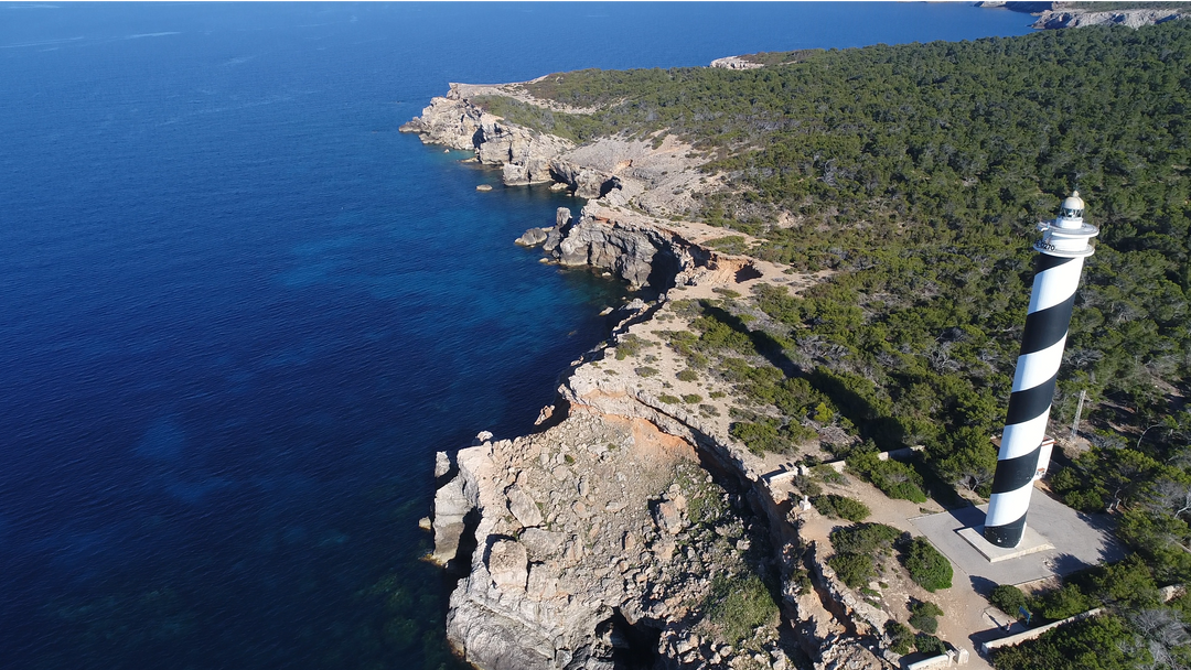 High Angle View of Black and White Striped Lighthouse on Rocky Coastline and Blue Sea - Download Free Stock Images Pikwizard.com