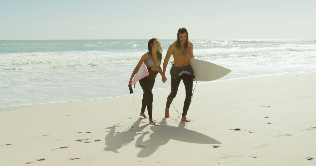 Couple Holding Hands on Beach with Surfboards - Free Images, Stock Photos and Pictures on Pikwizard.com