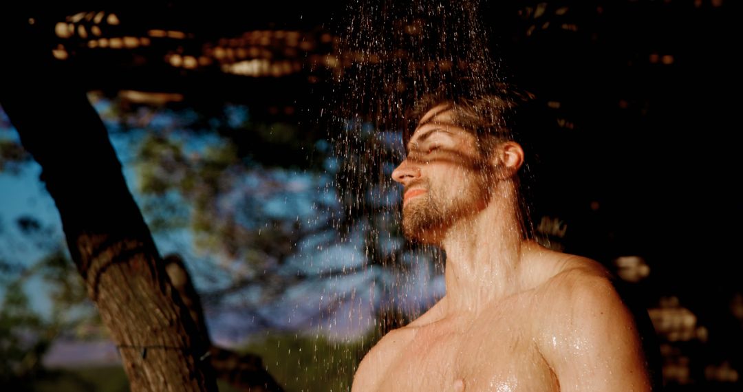 Young Man Enjoying Refreshing Outdoor Shower in Nature - Free Images, Stock Photos and Pictures on Pikwizard.com