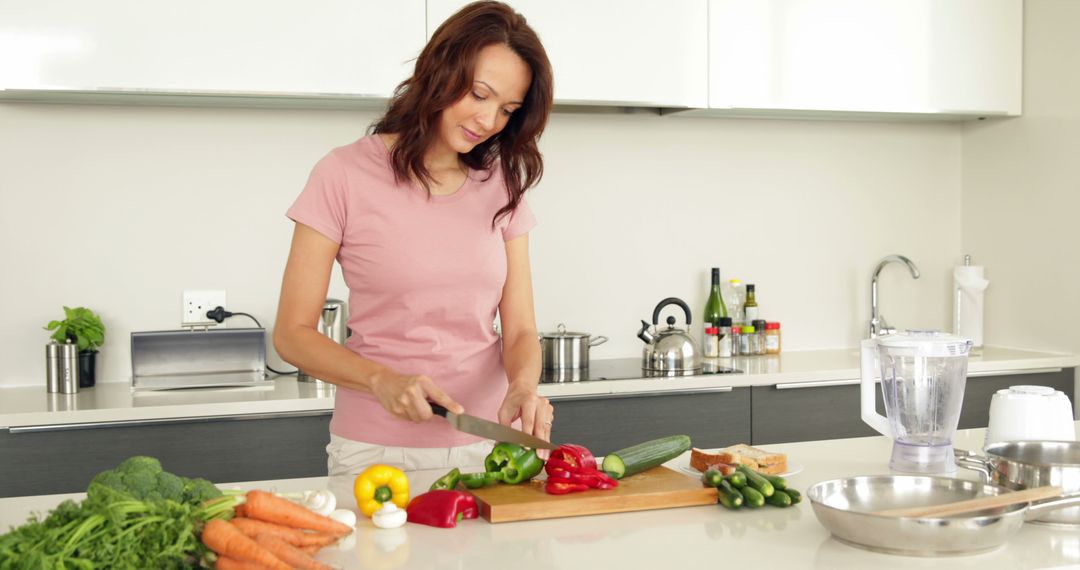 Woman preparing healthy meal cutting vegetables in modern kitchen - Free Images, Stock Photos and Pictures on Pikwizard.com