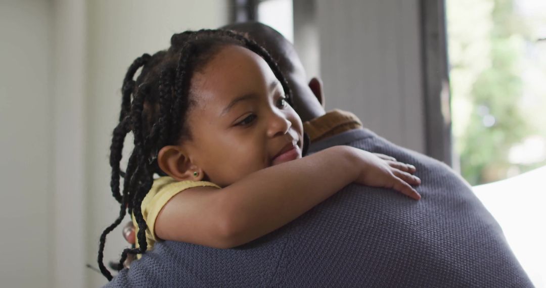 Father Hugging Daughter Creating Heartwarming Home Scene Near Window