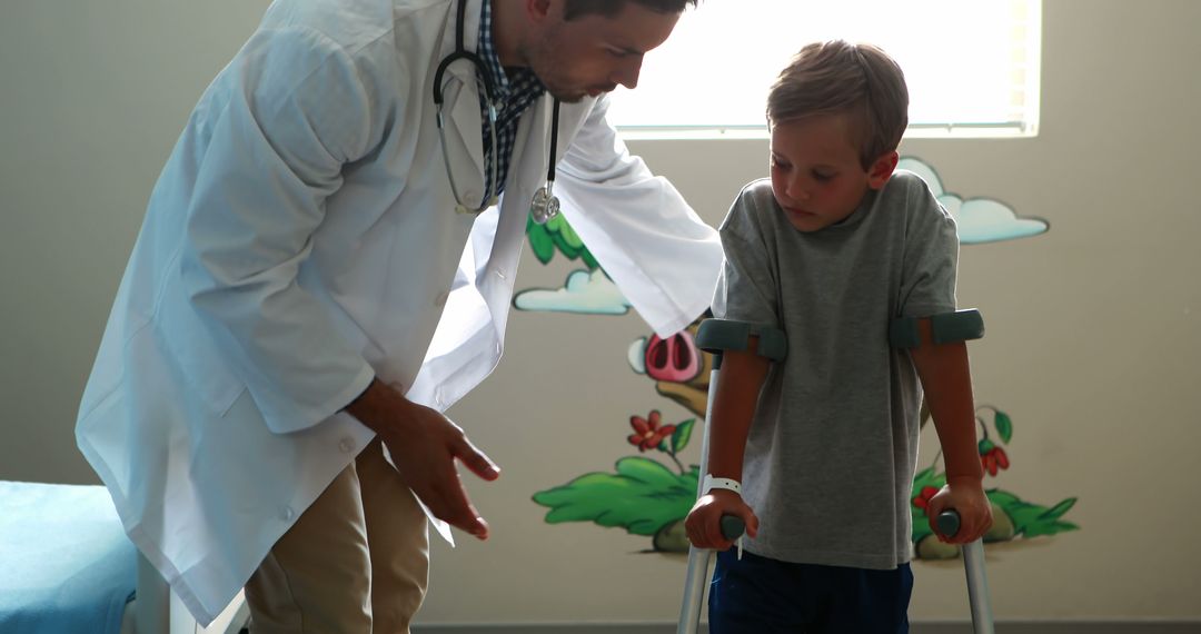 Doctor Assisting Young Boy Using Crutches in Pediatric Clinic - Free Images, Stock Photos and Pictures on Pikwizard.com