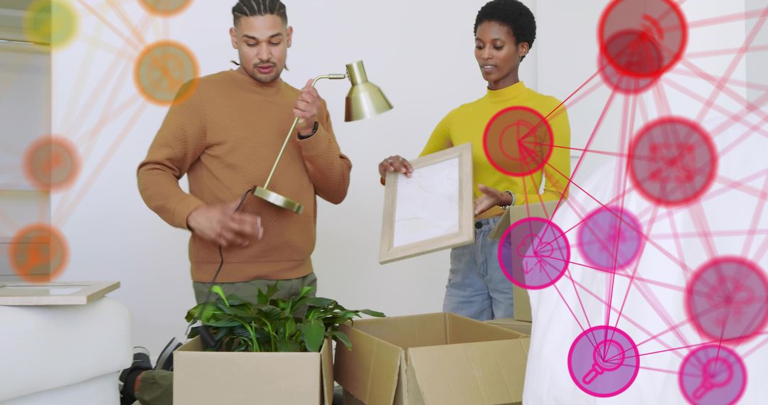 Young couple unpacking boxes and arranging lamp and frame during bright move-in day