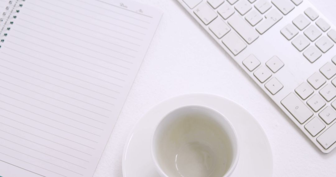 Clean Workspace with Keyboard, Empty Coffee Cup, and Lined Notebook - Free Images, Stock Photos and Pictures on Pikwizard.com